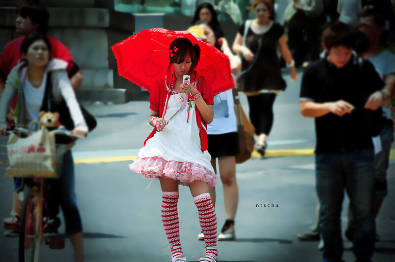 Woman with red umbrella in crowd