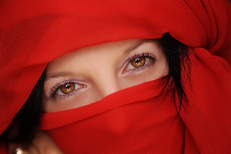 woman with red veil covering face