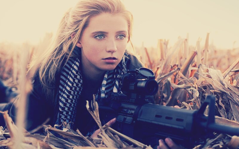 woman with rifle in cornfield