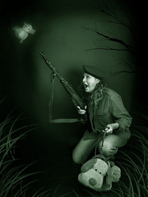 Woman with rifle in dark scene