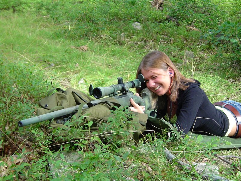 woman with rifle in grass