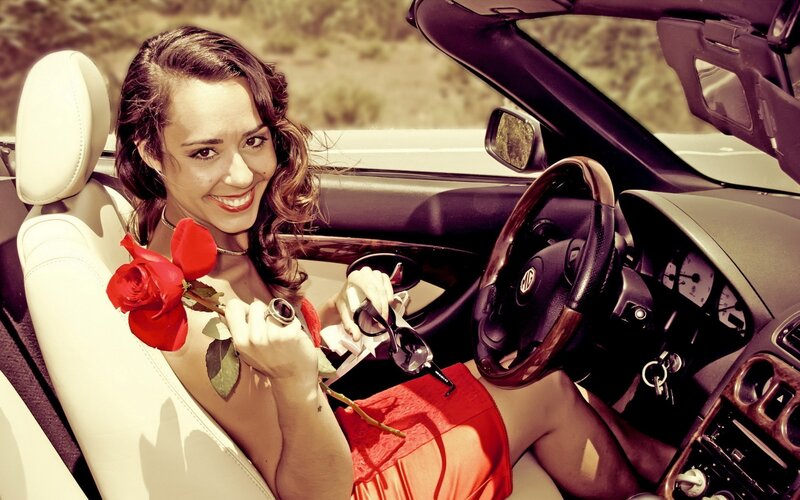 Woman with rose in convertible