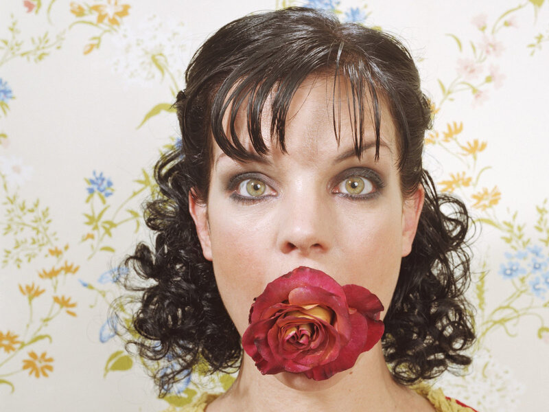 woman with rose in mouth