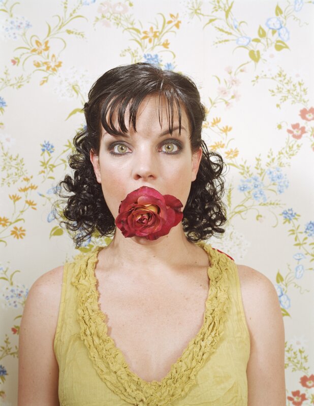 woman with rose in mouth
