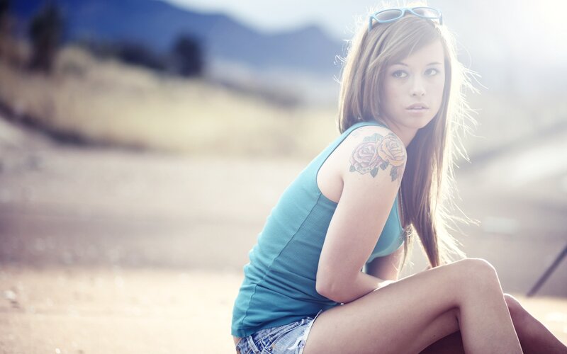 woman with rose tattoo outdoors