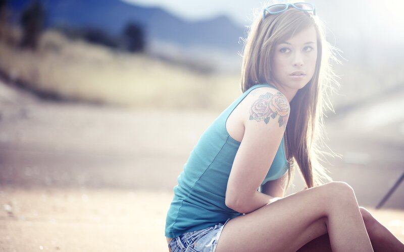 woman with rose tattoo outdoors