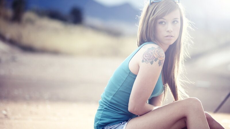woman with rose tattoo outdoors
