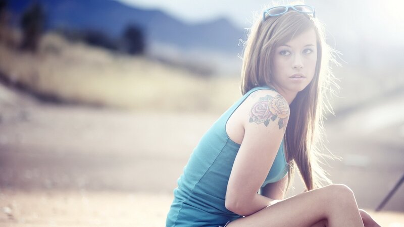 woman with rose tattoo outdoors