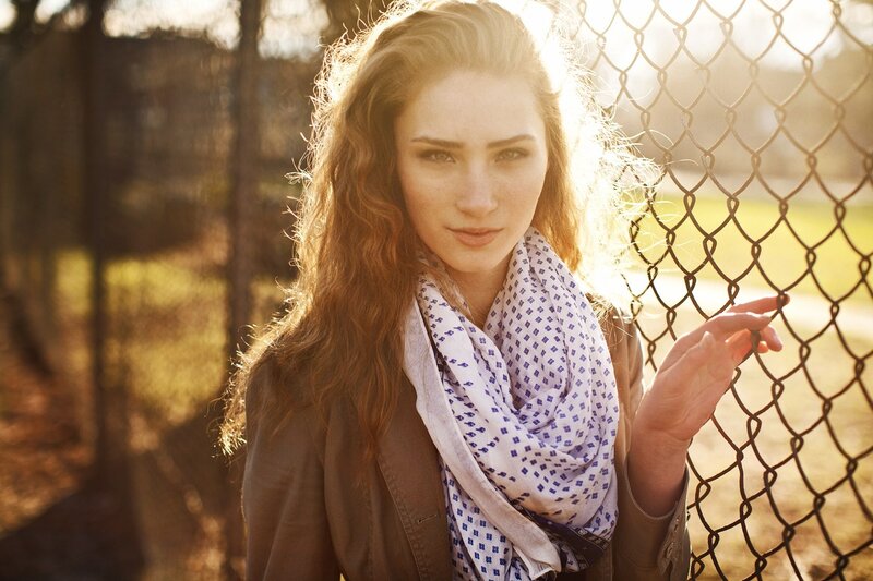 woman with scarf by fence