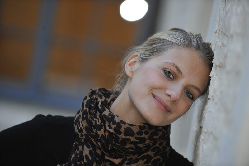 woman with scarf leaning on wall