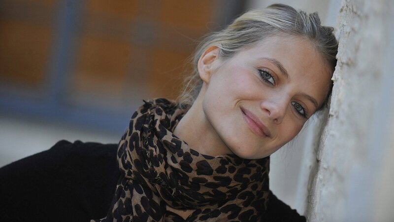 woman with scarf leaning on wall