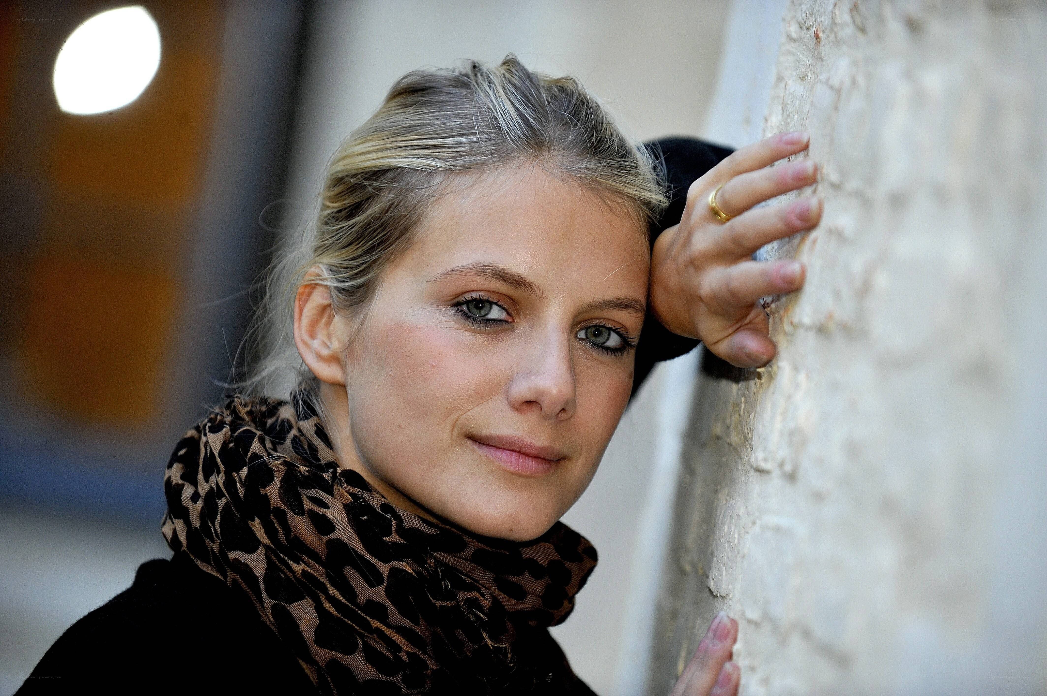 woman with scarf leaning on wall