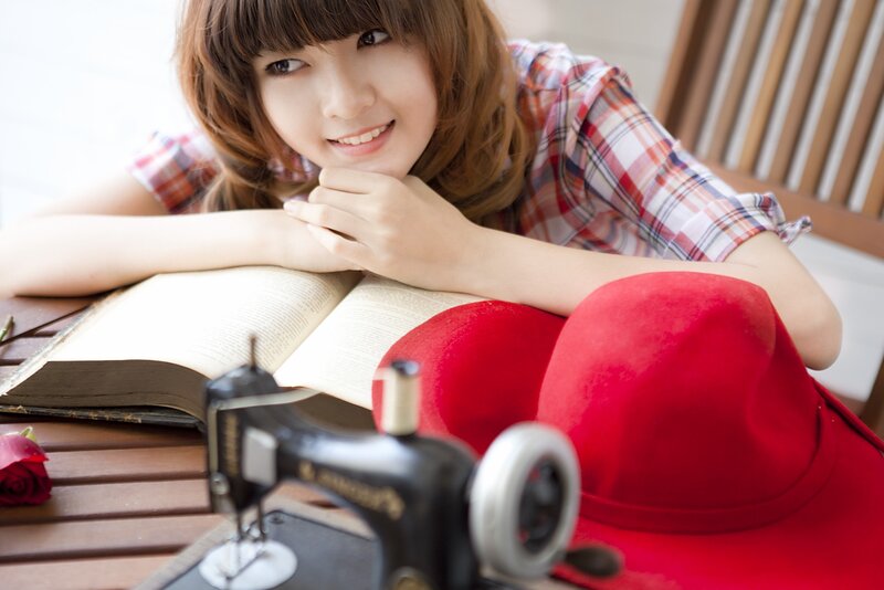 woman with sewing machine and book