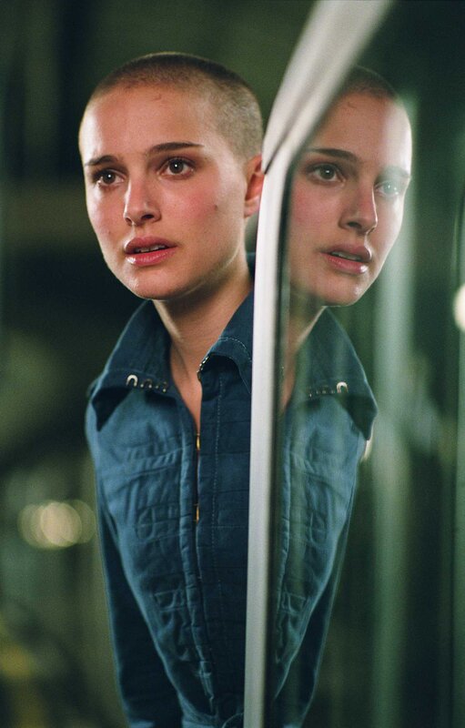 woman with shaved head in reflection