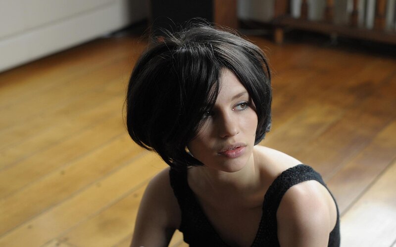 Woman with Short Black Hair — Contemplative, Photograph, Wooden Floor, Black Top