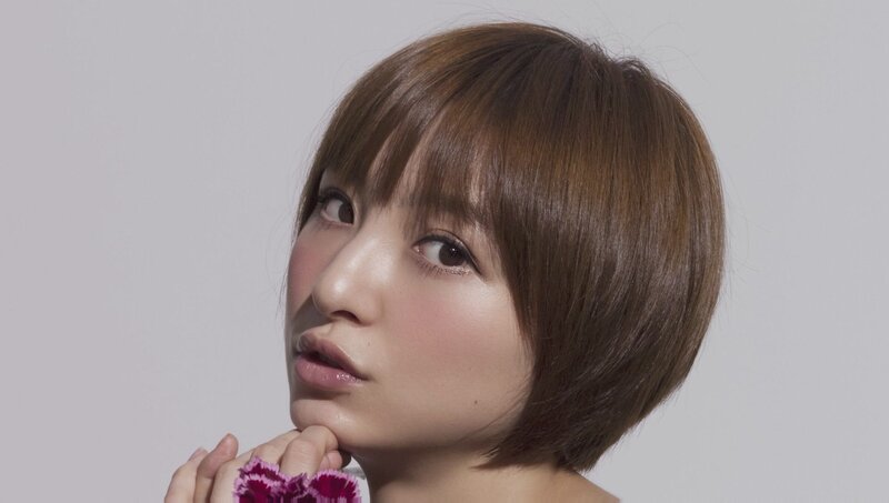 woman with short brown hair holding flower