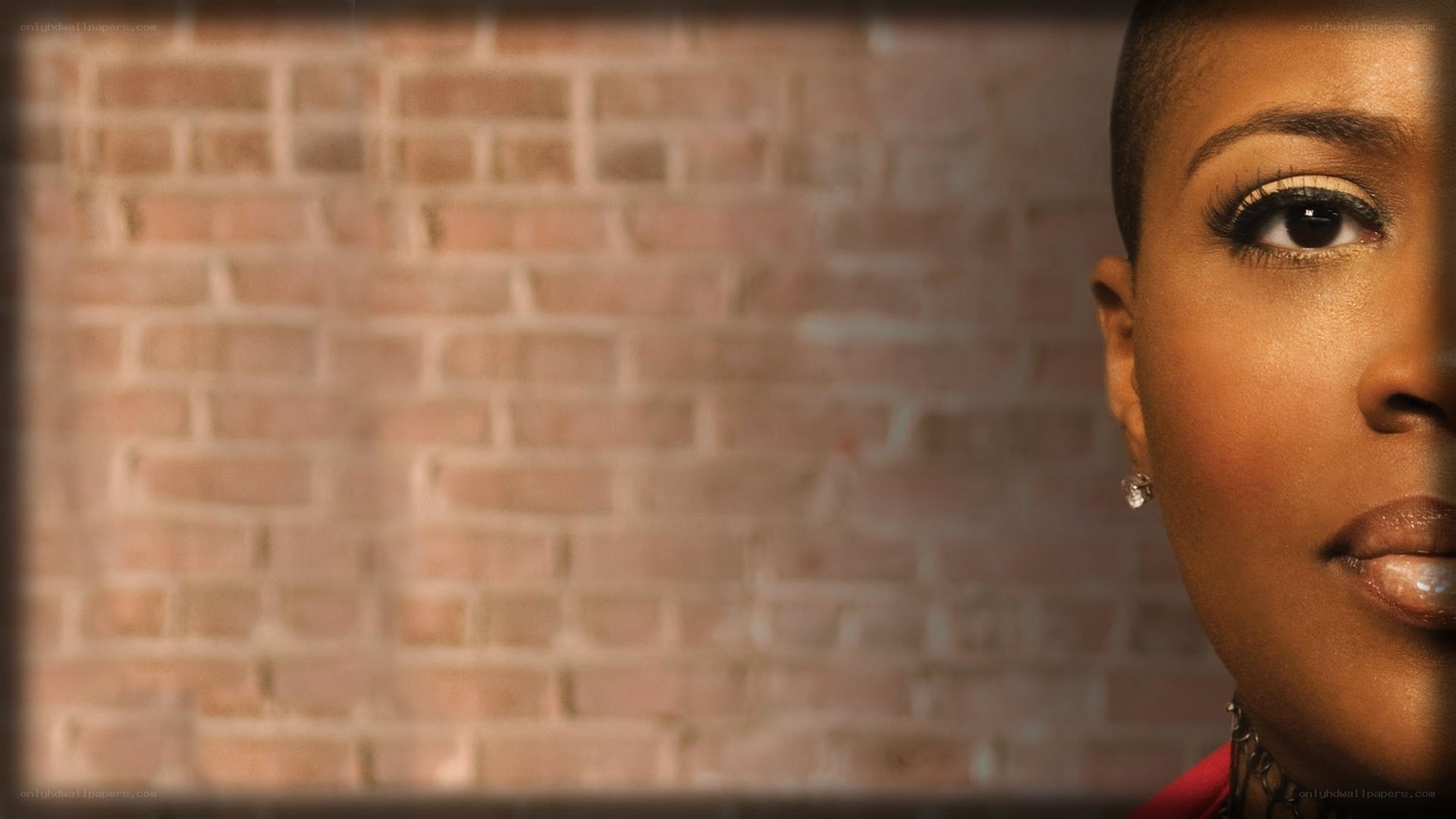 woman with short hair against brick wall