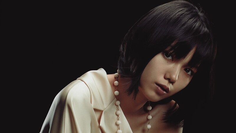 woman with short hair and pearl necklace