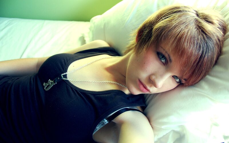 woman with short hair lying on bed
