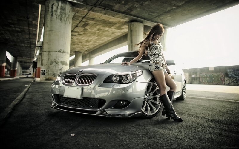 woman with silver car under bridge