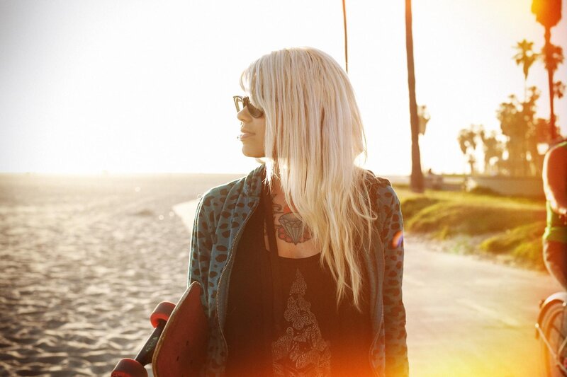 Woman with skateboard at beach