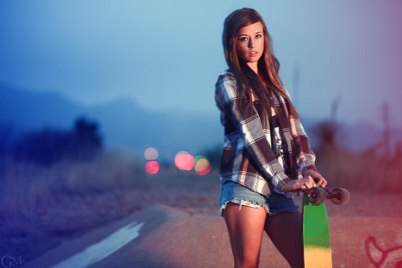 woman with skateboard at dusk