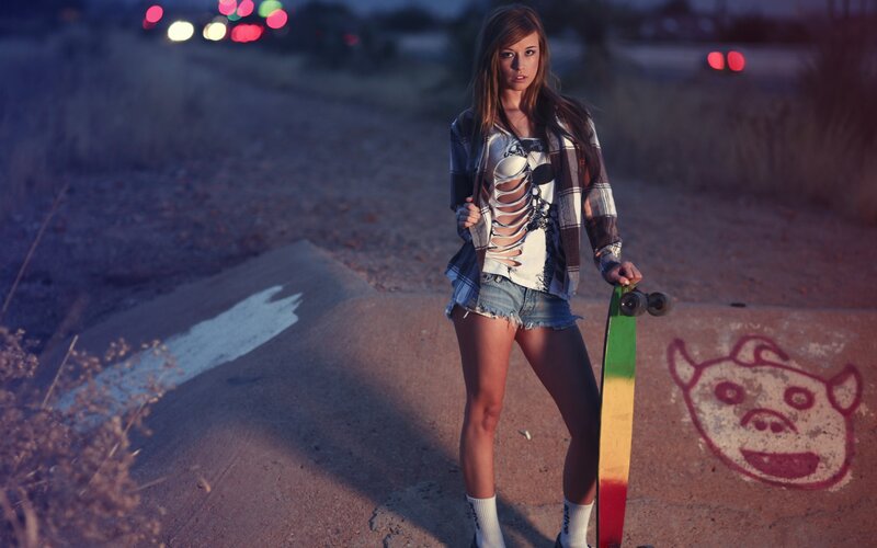 woman with skateboard at dusk