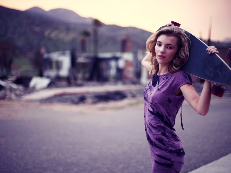 Woman with skateboard at dusk