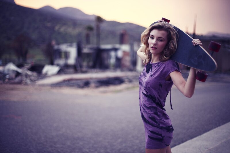 Woman with skateboard in urban setting