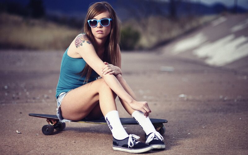 woman with skateboard on road