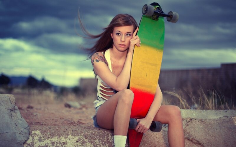 woman with skateboard on wall