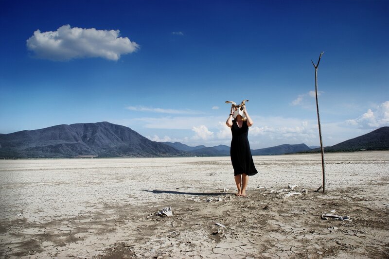 Woman with skull in desert