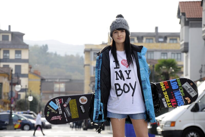 Woman with snowboard in town
