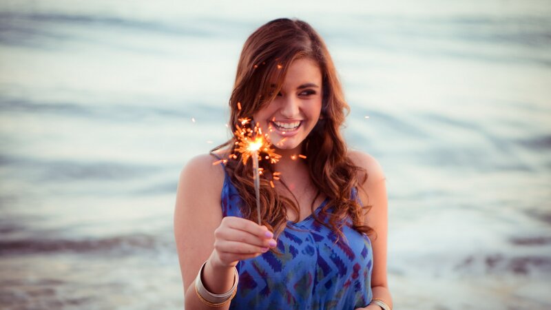 Woman with sparkler at beach