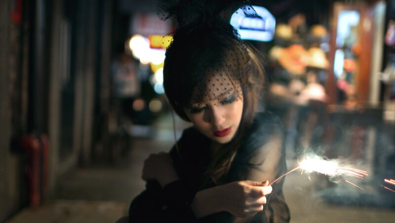 Woman with sparkler at night