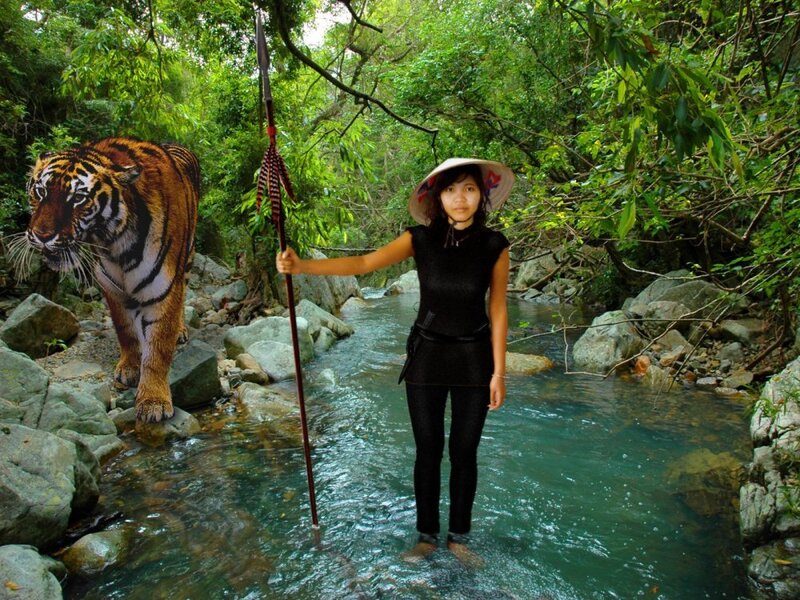 Woman with spear in jungle stream