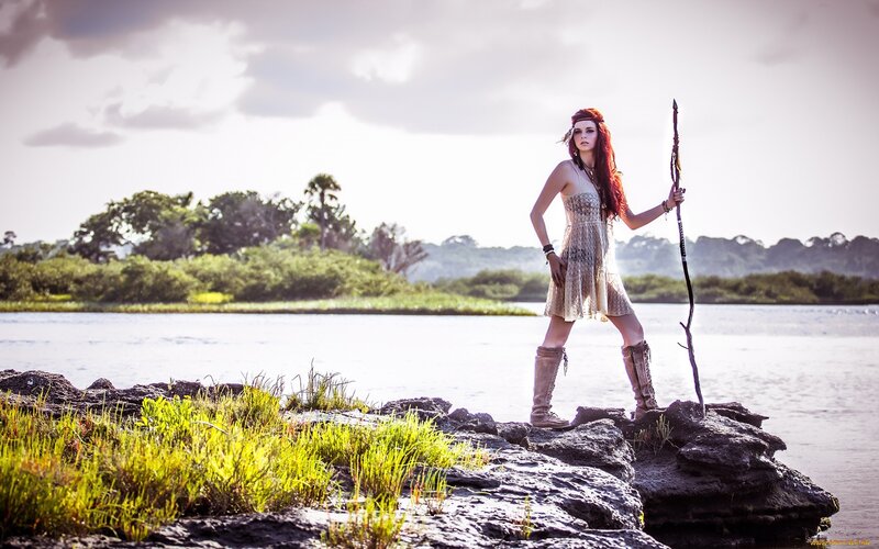 woman with staff by river