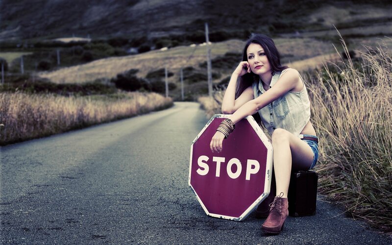 woman with stop sign on road