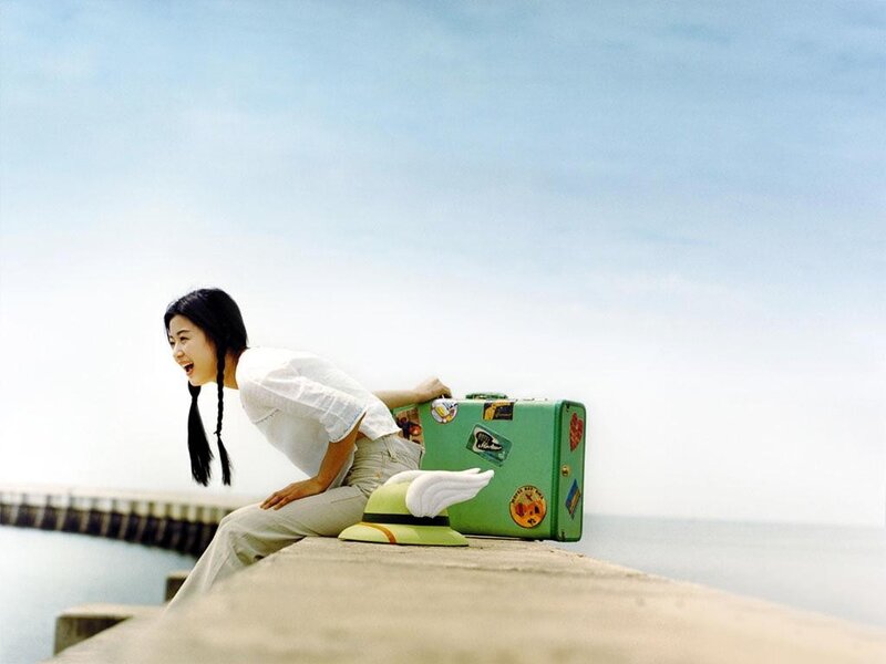 woman with suitcase at pier