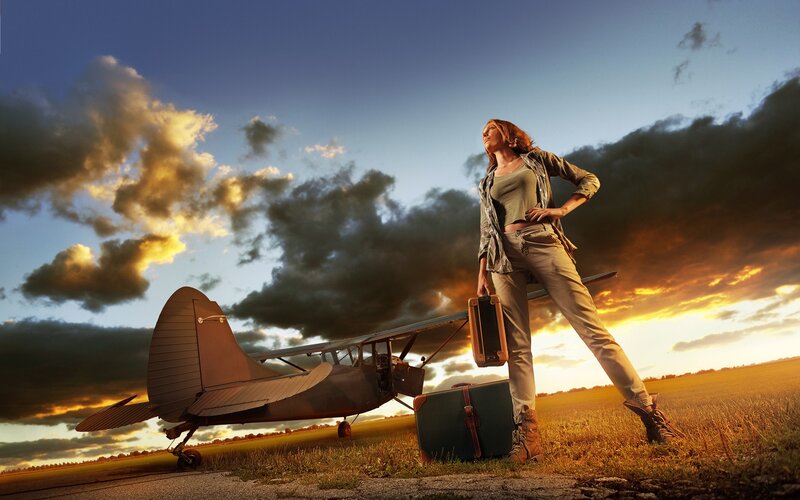 Woman with suitcase near airplane
