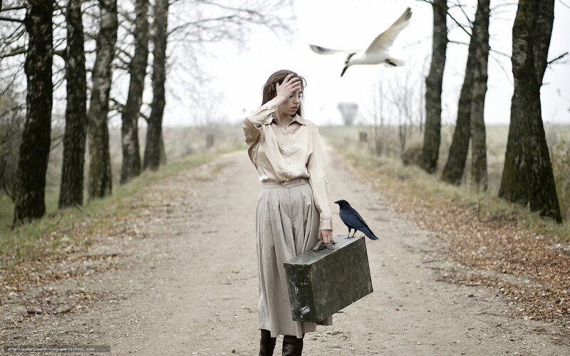 Woman with suitcase on a path