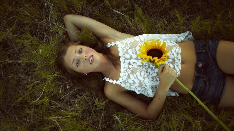 Woman with sunflower in field