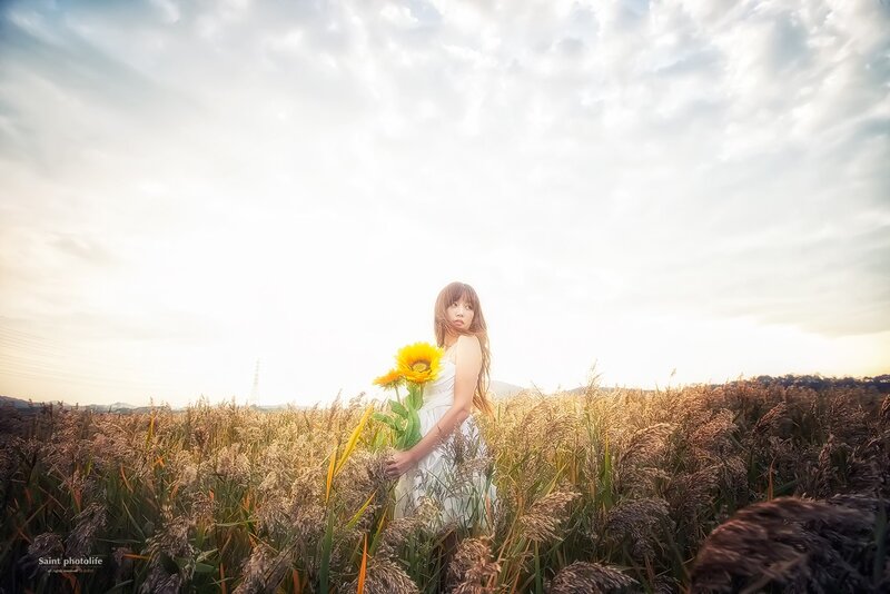 Woman with sunflower in field