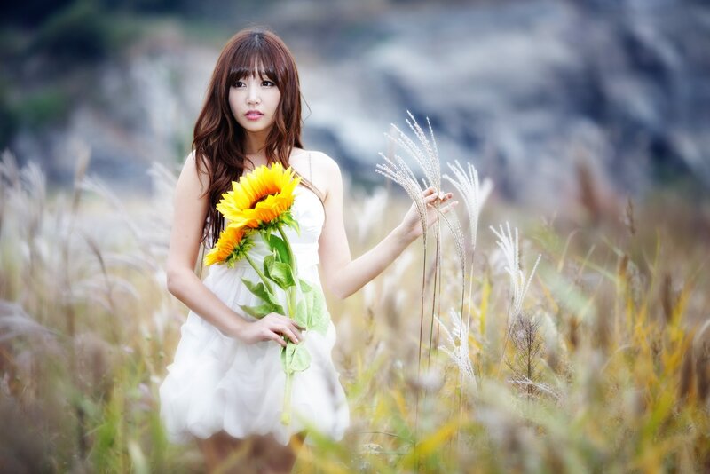 Woman with sunflower in field