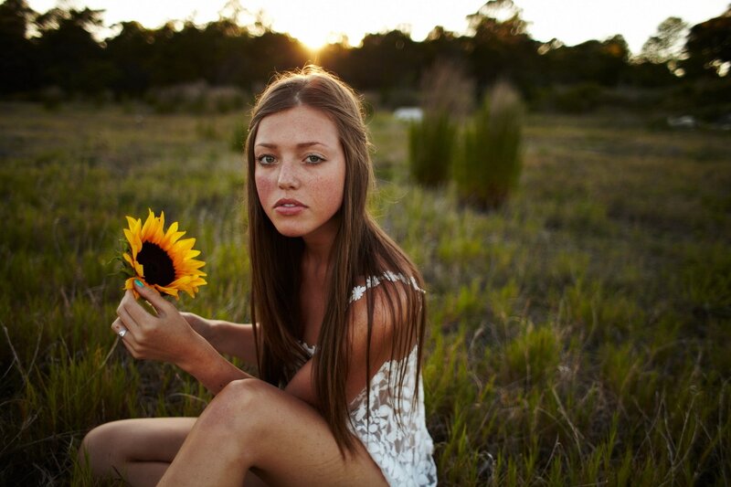 Woman with sunflower in field