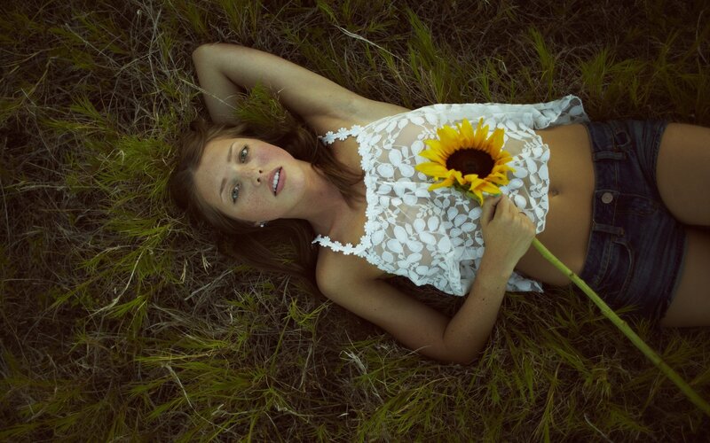 Woman with sunflower in field