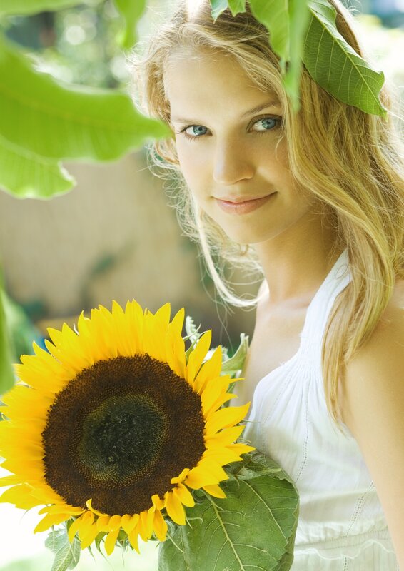Woman with sunflower in garden