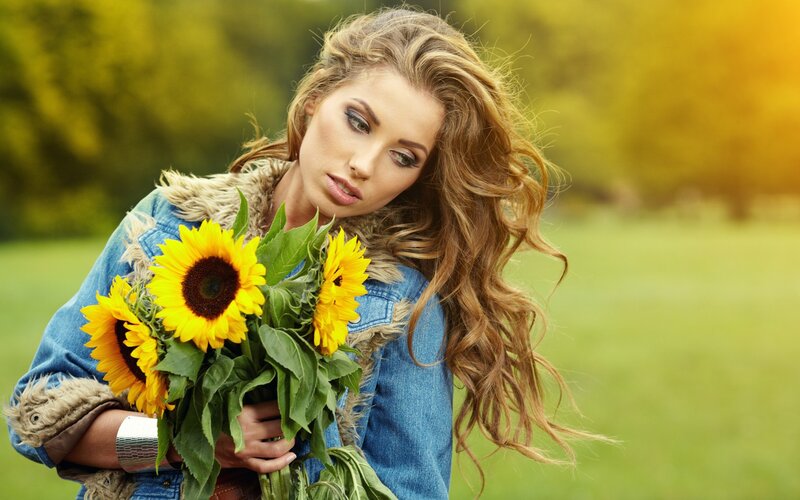 Woman with sunflowers in field