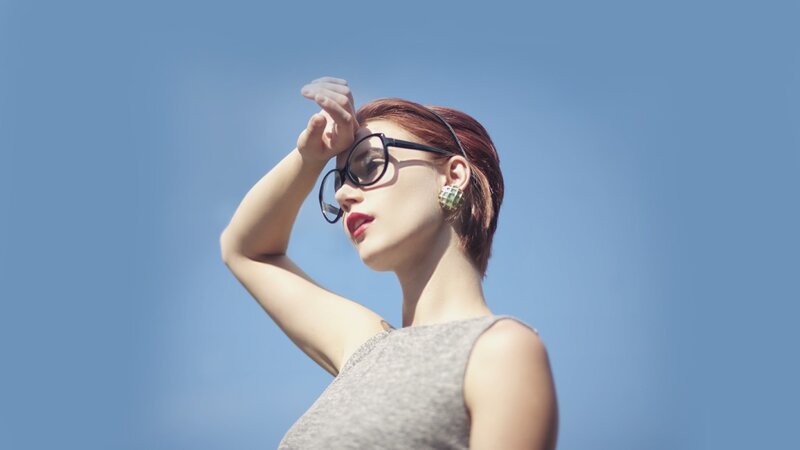 woman with sunglasses against blue sky