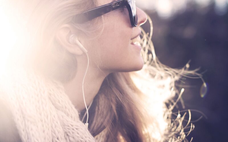 woman with sunglasses and earbuds